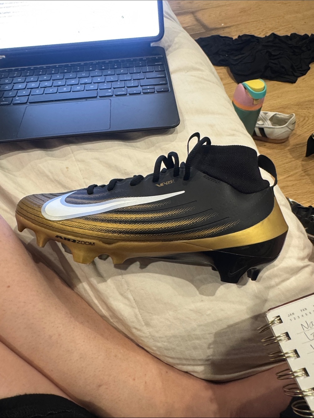 Nike Black and Gold Football Cleat with White Swoosh